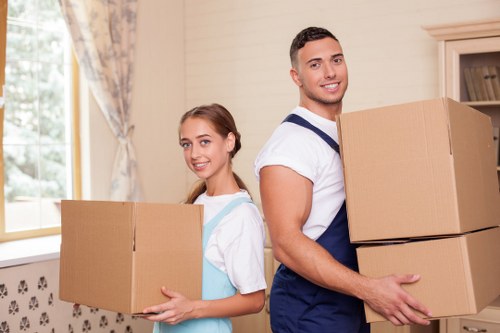 Professional removal team handling boxes in a Poplar apartment building